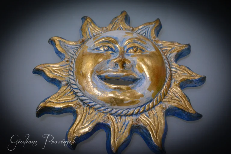 Sole di terracotta pitturato e decorato con foglia oro